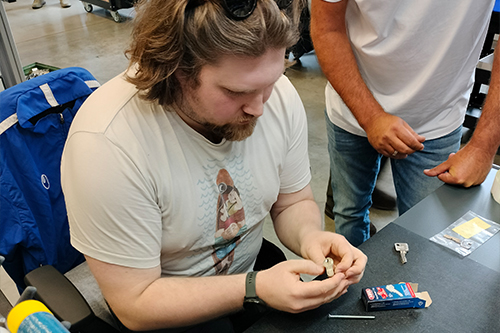 Sam sitting at a work bench looking at an ABUS cylinder